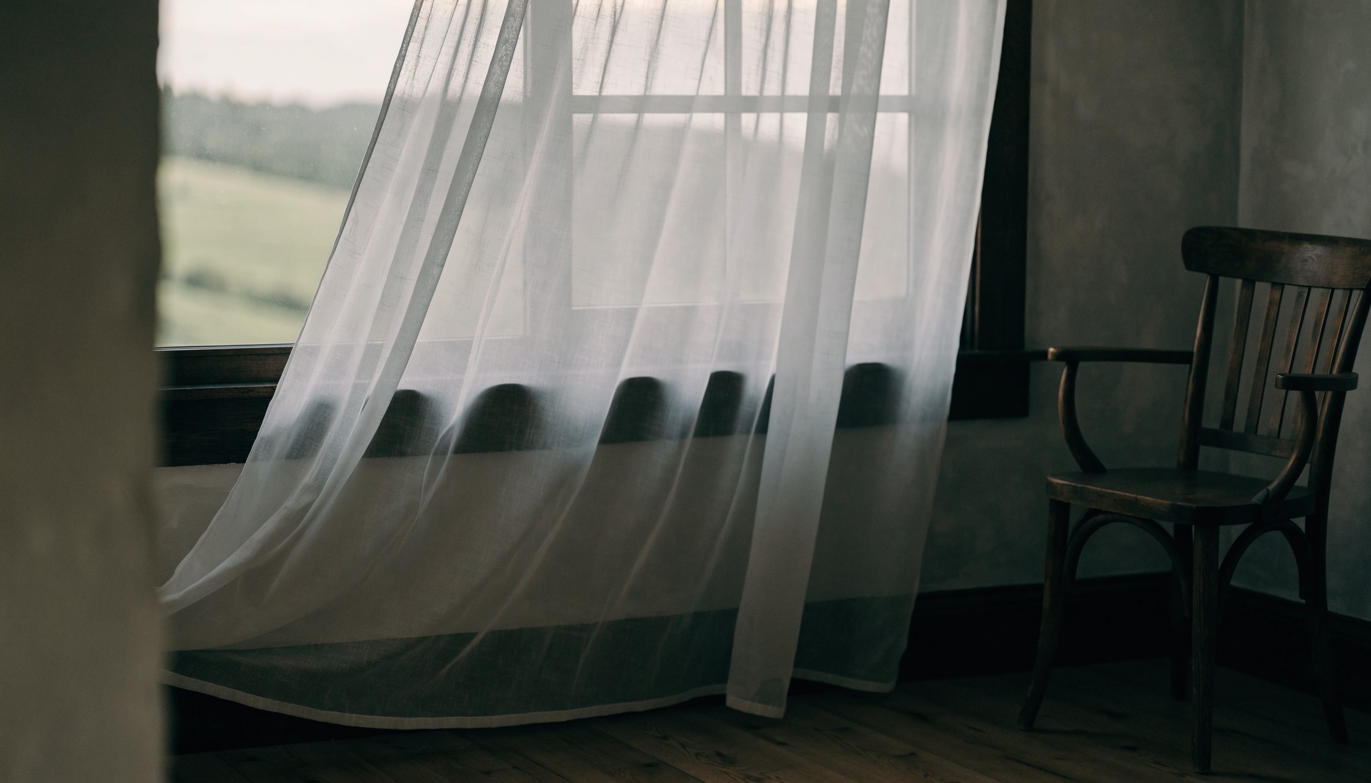 Sheer curtain over a window in a quiet rural Missouri home, suggesting privacy